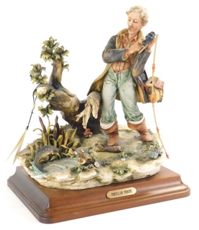 A Capodimonte figure group, Porcelane Principe figure fishing, on wooden base, signed, 36cm high.