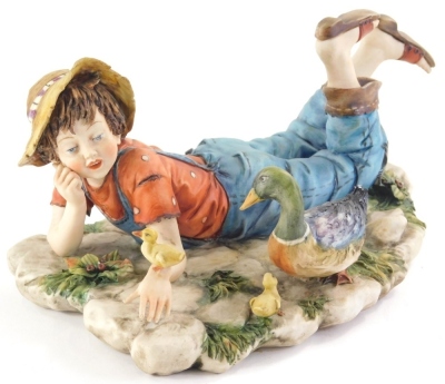 A Capodimonte boy figure and a duck, signed Volta, marks beneath, 20cm wide.