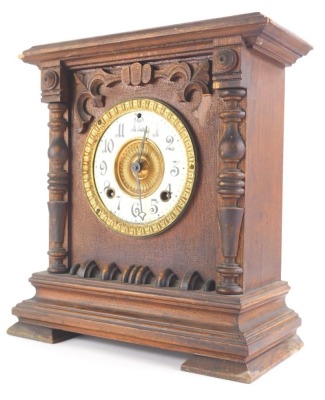 An early 20thC Ansonia oak cased mantel clock, with raised carvings, quarter columns, 12cm dia. Arabic enamel dial and compressed feet, with eight day movement, 31cm high.