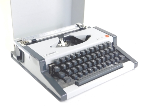 A vintage Olympia Traveller typewriter, in grey and cream, in outer case, 32cm wide.