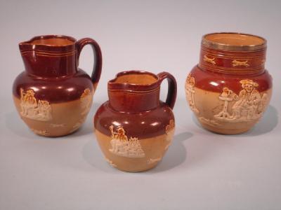 A Doulton Lambeth vase with a silver rim and two stoneware jugs