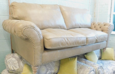 A modern leather Chesterfield style three seat settee, with studded arms and limed oak turned legs, 213cm wide, 88cm deep.