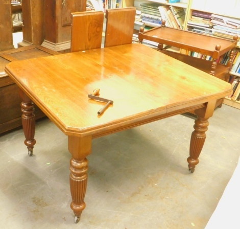 A late Victorian walnut extending dining table, the rectangular top with canted corners, on turned and reeded legs with castors, two loose leaves, 76cm high, the top 106cm x 178cm.