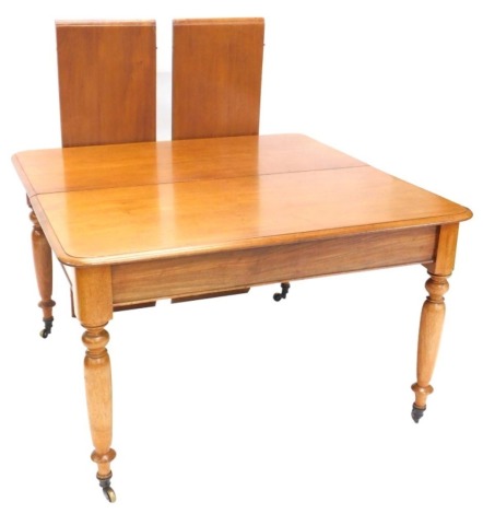 An early Victorian mahogany extending dining table, the rectangular top with a moulded edge on turned legs with brass casters, two loose leaves, 71cm high, 180cm wide, 184cm long.