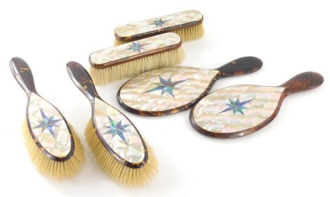 An early 20thC mother of pearl and tortoise shell dressing table set, to include clothes brushes, 15cm wide, hair brushes, and hand mirrors. (6)