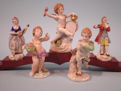 A pair of Dresden figures of musicians and three continental porcelain putti