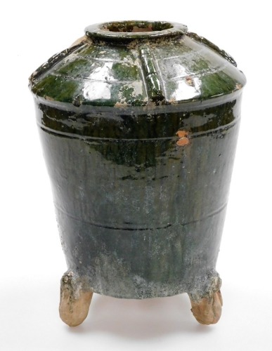 An Eastern Han style green glazed earthenware granary jar, of tapered shouldered design, raised on three feet, 31cm high.