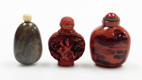 A Chinese hardstone snuff bottle of pebble form and two others, including a faux Cinnabar bottle and a glass faux realgar snuff bottle, 6.2cm high, 6cm high and 6.8cm high respectively, (3).