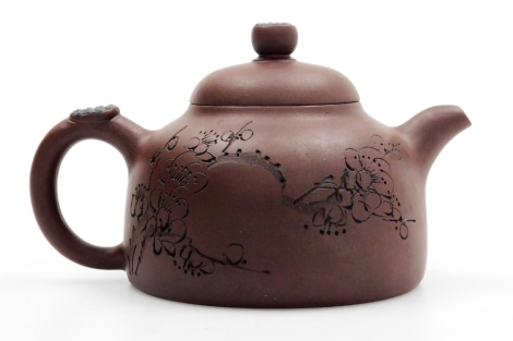 A Chinese Yixing tea pot, with incised prunus design and inscriptions, with impressed seal mark and inscription to the base, 6.5cm high.