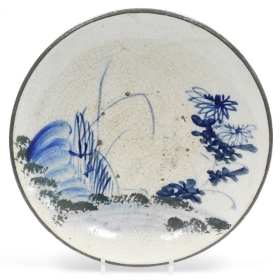 A Japanese folk art stoneware dish, with hand painted flowering shrubs and crackle glaze, 31.5cm high.