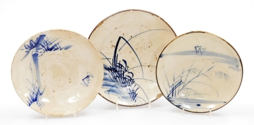 Three Japanese folk art stoneware dishes, with hand painted decoration of bamboo, rushes and sailing boats, 24.5cm high, 21.5cm high and 20.5cm high.