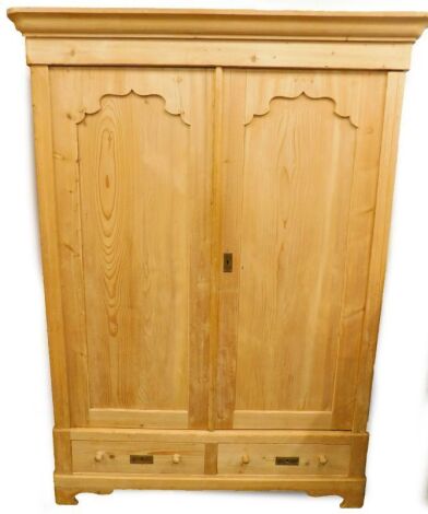 A continental pine armoire or cupboard, with a moulded cornice above two panelled doors, the base with two plinth drawers, on bracket feet, 151cm wide.