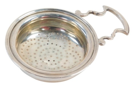 A George V silver tea strainer, with scroll handle and pierced bowl, London 1912, 1¾oz.