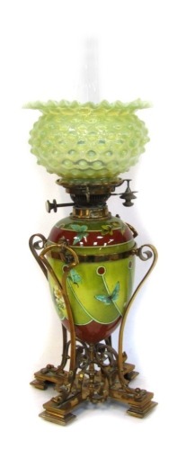 A Victorian pottery oil lamp, the green vaseline glass flared shade, a chimney on a ceramic Doulton Art Nouveau style body, with Gothic brass mounts, 65cm high.