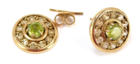 A pair of 9ct gold peridot and CZ set cluster earrings, each of circular design with central peridot surrounded by CZ stones, on single pin back on butterfly backs, 2.5g all in. (AF)