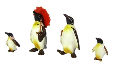 Four Beswick penguins, comprising one with parasol, adult penguin and two children, tallest 11cm high.