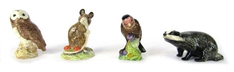 Four Beswick animal ornaments, comprising badger, owl, mouse with berry, and a goldfinch, tallest 9cm high.