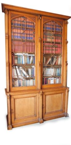 A Victorian Gothic oak cabinet bookcase, with moulded cornice, two tall astragal glazed doors, with moulded panel doors to base, 285cm high, 170cm wide, 53cm deep. Please note this lot is located on site at the former offices of Messrs Stapleton & Son So