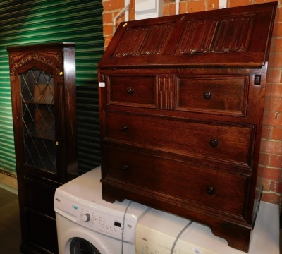 A dark oak linen fold carved bureau, together with a similar corner cabinet. (2)