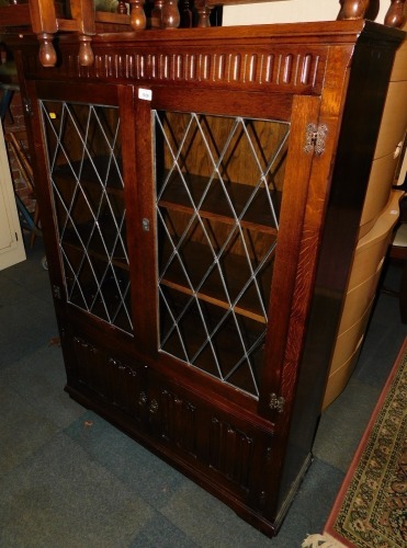 A stained oak lead glazed bookcase, with lower cupboards.