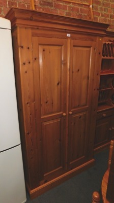 A pine double wardrobe, with shelf and hanging rail.