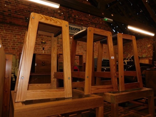 Three pine bar stools, with brown upholstery.