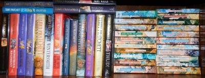 A group of Terry Pratchett books, including Going Postal, The Truth, Winter Smith, The Fifth Elephant, Thief of Time, Wyrd Sisters, etc. (1 shelf)