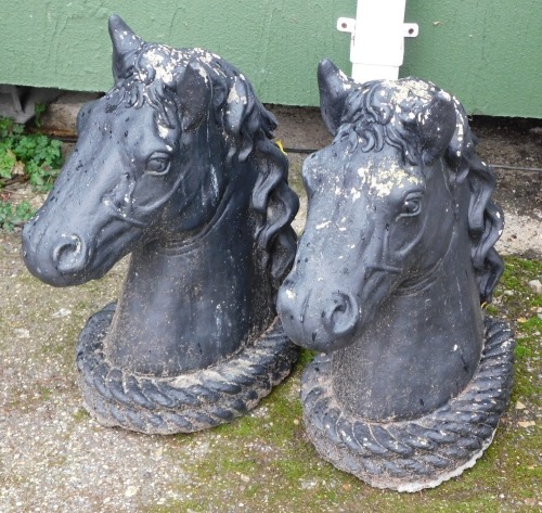 Two painted reconstituted stone horse's heads, 48cm high.