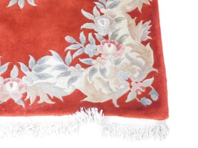 A Chinese cut wool rug, on a red ground with cream flowers, and tassel ends, 187cm x 125cm. - 3