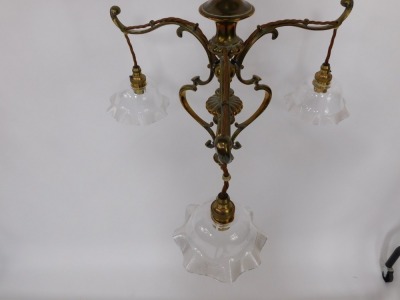 A Victorian brass three branch electrolier, the scroll supports, on chain hanging, with fluted frilled glass shades, 61cm high. - 2