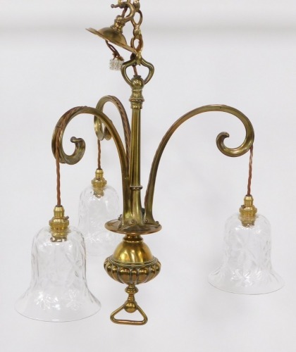 A brass three branch hanging chandelier, with chain drop, on stem and fluted bulbous centre, with floral cut glass bell shaped shades, 63cm high.