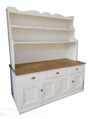 A Victorian painted pine kitchen dresser, the dresser back with a moulded cornice above two waterfall shelves, painted in white with a substantial three plank pine top, above arrangement of three drawers over a pair of twin cupboard doors, the base painte