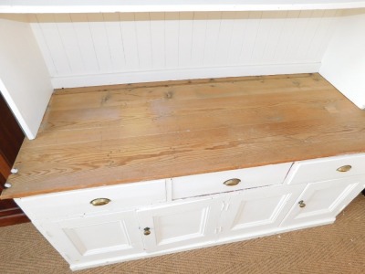 A Victorian painted pine kitchen dresser, the dresser back with a moulded cornice above two waterfall shelves, painted in white with a substantial three plank pine top, above arrangement of three drawers over a pair of twin cupboard doors, the base painte - 3