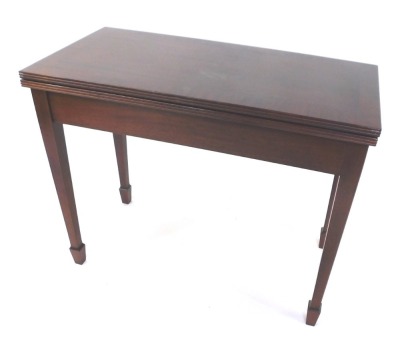 A Georgian style mahogany card table, the fold over top with reeded edge, enclosing a baize interior, raised on square tapering legs, and spade feet, 72cm high, 87cm wide, 44cm deep.