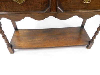 An early 20thC oak dresser, the dresser plate top with pierced and carved frieze over two shelves, above two drawers, on ring turned legs united by an under tier, 194cm high, 121cm wide, 45cm deep. - 4