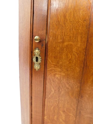 A 19thC oak hanging corner cupboard, the pediment above a single panelled door, with brass handle and escutcheon, enclosing three shelves, 102cm high, 68cm wide, 39cm deep. - 3