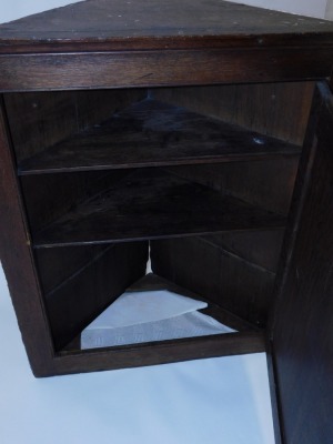 A 19thC oak hanging corner cupboard, the two panelled door with brass escutcheon and handle, 95cm high, 80cm wide, 40cm deep. - 3