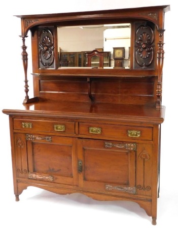 A Victorian Art Nouveau mahogany mirror back sideboard, the mirror backed top with floral panels, and single shelf with turned column supports, above two drawers and two doors, raised on turned feet, 197cm high, 152cm wide, 55cm deep.