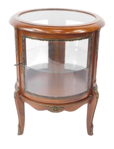 A Louis XV style mahogany bijouterie table, of circular form with brass mounts, with glazed top and sides, glass internal shelf, raised on cabriole legs , 74cm high, 56cm diameter.