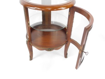 A Louis XV style mahogany bijouterie table, of circular form with brass mounts, with glazed top and sides, glass internal shelf, raised on cabriole legs , 74cm high, 56cm diameter. - 4