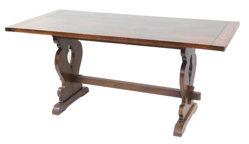 A Victorian oak refectory table, the planked top raised on shaped end supports, united by a stretcher, 76cm high, 167cm wide, 84cm deep.