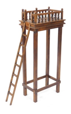 An Eastern mango wood bird feeding table, the galleried top raised on slender tapering square legs, united by a box stretcher, and a side ladder, 103cm high, 45cm wide, 28cm deep.