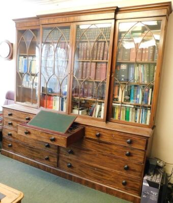 An early 19thC flamed mahogany break front cabinet and secretaire bookcase, with moulded cornice, Gothic arch astragal glazed doors to upper part, the lower having a combination of drawers, including a fitted central secretaire section with six compartmen - 2