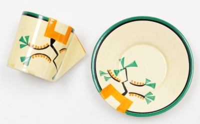 A Clarice Cliff Bizarre Ravel pattern coffee can and saucer, the coffee can with an angular handle, both pieces painted with an abstract design in green, orange and black against a pale yellow ground, printed marks, the can 5.7cm high, the saucer 10cm dia - 2