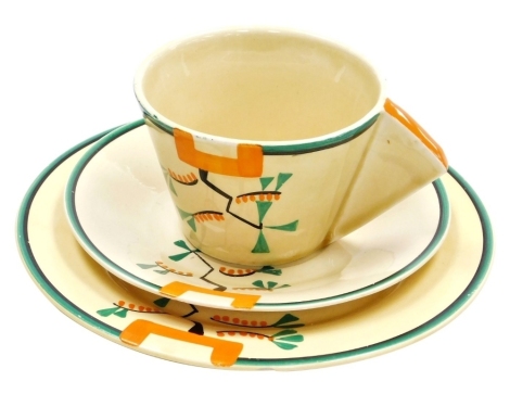 A Clarice Cliff Bizarre Ravel pattern trio, comprising teacup with angular handle, saucer and plate, each piece hand painted with an abstract design in green, orange and black against a pale yellow ground, printed marks, the cup 6.2cm high, the saucer 14.