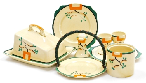 A group of Clarice Cliff Bizarre Ravel pattern wares, comprising four division egg cup stand, 16cm wide and two associated egg cups, 5.5cm high, pepper pot, 8cm high, cheese dish and cover, 19cm wide, jar, 7.5cm high (lacking lid), octagonal sandwich plat