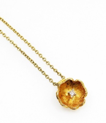 An 18ct gold diamond set floral pendant and chain, the flower pendant in brushed gold with central tiny diamond, approx 0.10ct, on a fine link chain, the pendant 2cm high, the chain 40cm long overall, 5.9g all in.