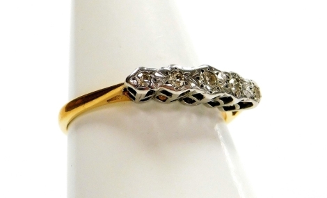 An 18ct gold and platinum five stone diamond dress ring, with illusion set tiny diamonds, in a raised basket, with pierced shoulders, ring size M, 1.9g all in, boxed,