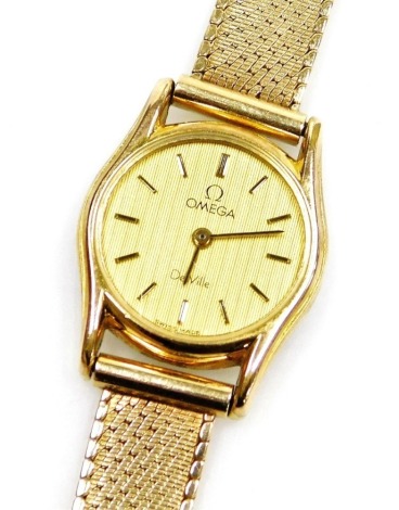 An Omega De Ville lady's 9ct gold wristwatch, with small circular watch head, on a bark effect type dial, the dial 1.5cm wide, 18cm long overall, 20.9g all in, boxed.