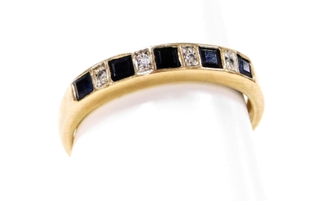 A 9ct gold half hoop dress ring, set with five square cut sapphires and four tiny diamonds, ring size M½, 1.9g all in.